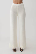 Woman wearing white crochet pants.