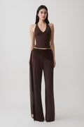 Woman wearing a brown slinky and mesh top with slinky gathered wide leg pants.