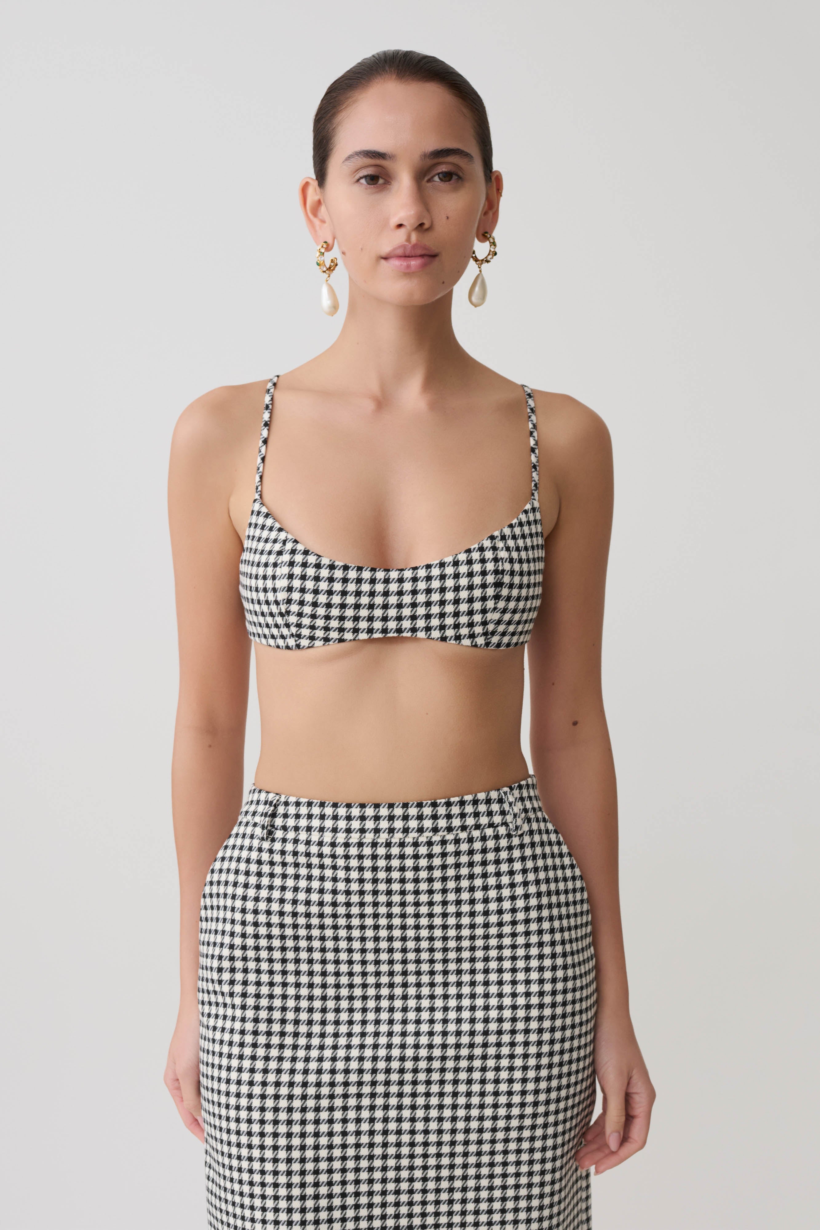 Woman wearing a black and white checkered tweed bralette.