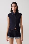 Woman wearing dark blue collared denim longline top with matching denim shorts.