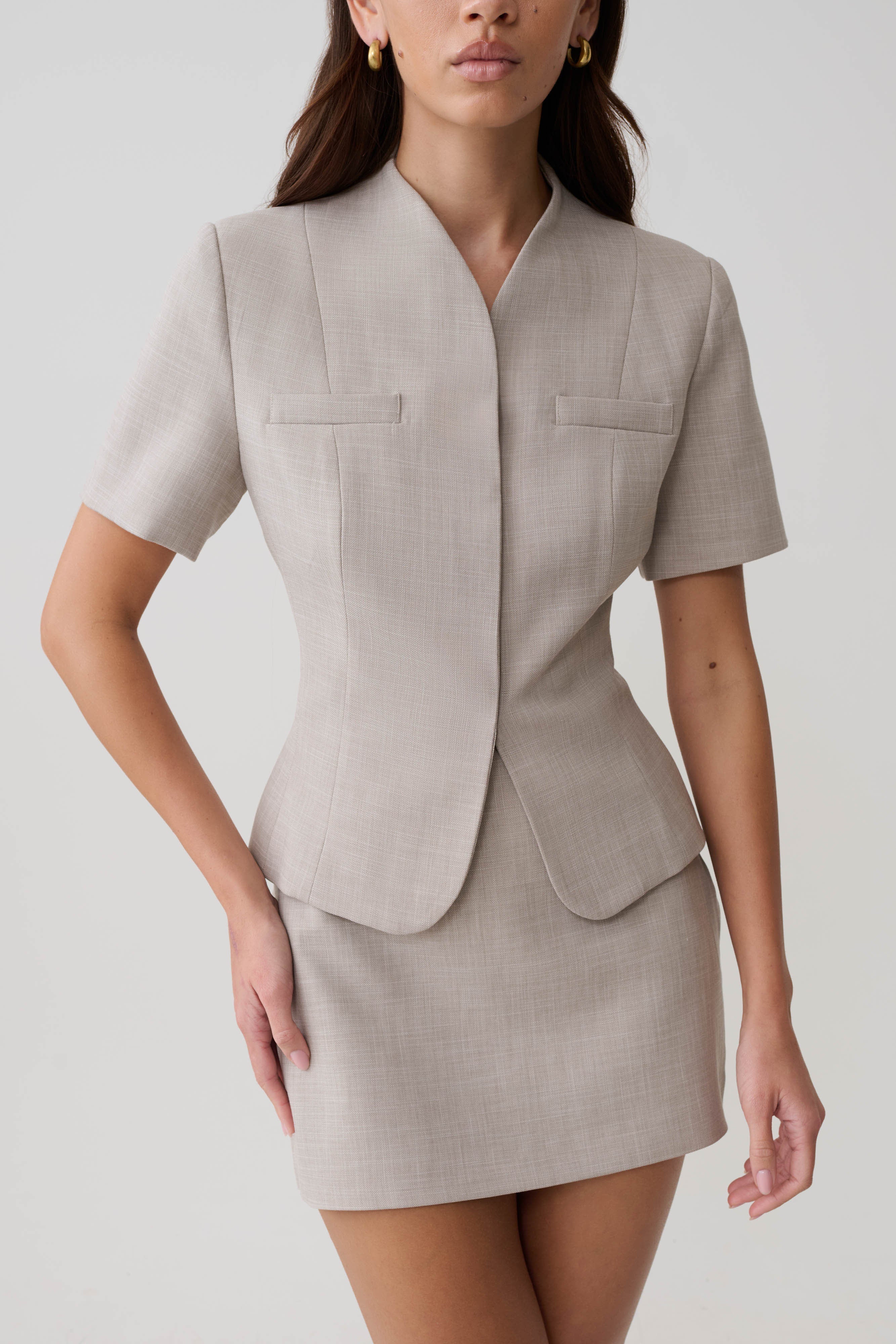 Woman wearing a grey suiting short sleeve top.