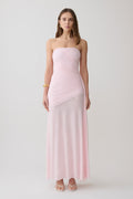Woman wearing a pink strapless ruched mesh maxi dress.