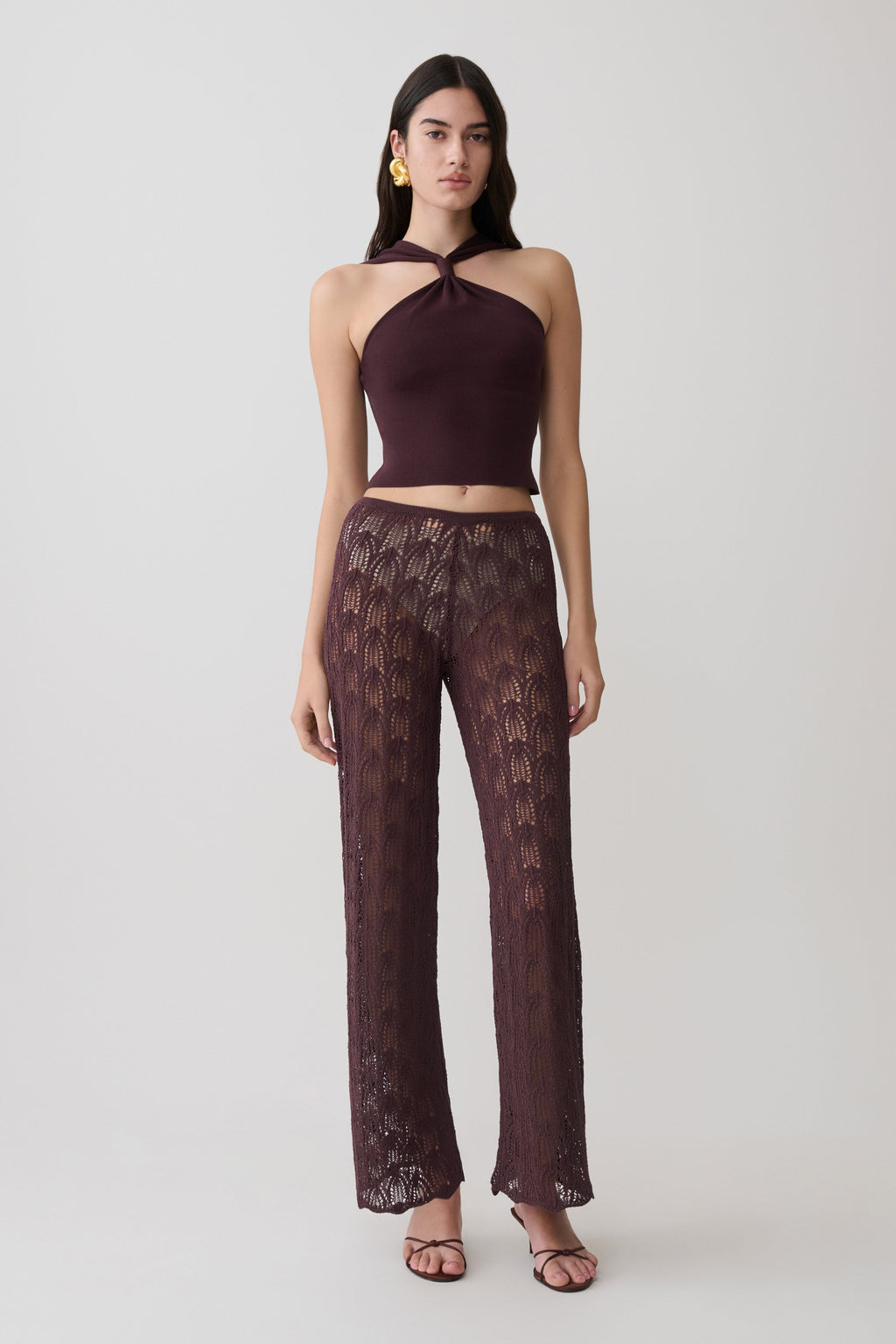 Woman wearing brown crochet pants.