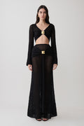 Woman wearing crochet long sleeve cropped top with matching maxi skirt.